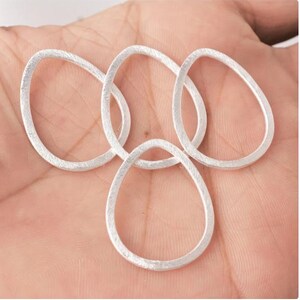 Puede incluir: Cuatro anillos ovalados de plata con acabado texturizado.