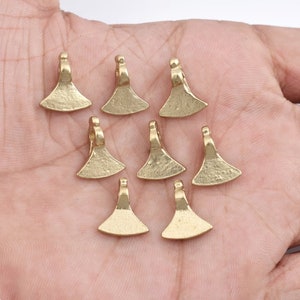Puede incluir: Diez colgantes de metal de color dorado en forma de cabeza de hacha con textura martillada. Los colgantes tienen un bucle en la parte superior para sujetarlos a una cadena o cordón.