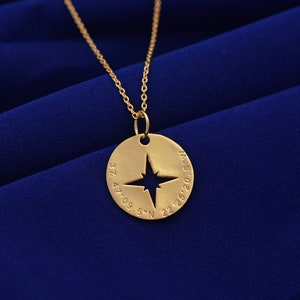Puede incluir: Collar de oro con un colgante de brújula con una estrella recortada y coordenadas grabadas alrededor del borde: 37.47.09.5"N 22.26.20.5"W.