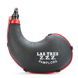 Op de afbeelding: Zwarte leren wijnzak met een rode rand en een zwarte tuit. De zak heeft de tekst "LAS TRES Z.Z.Z. PAMPLONA" in wit erop gedrukt.