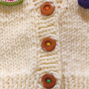 Button details of the hand knit design cardigan for children.