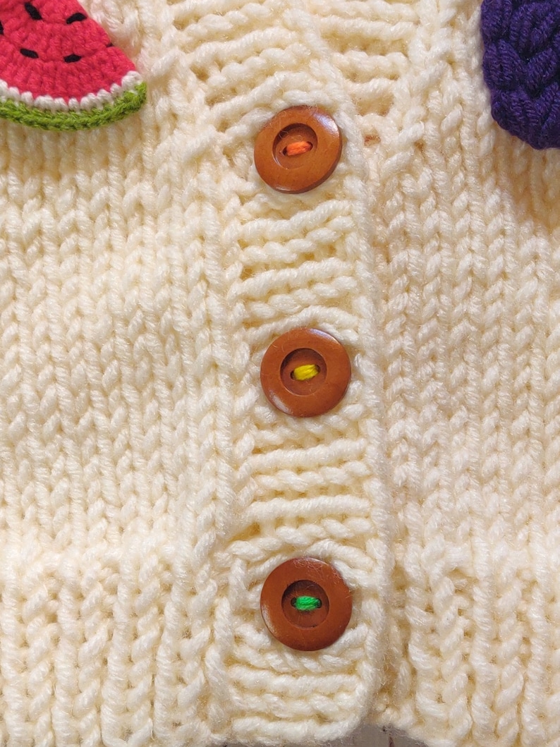 Button details of the hand knit design cardigan for children.