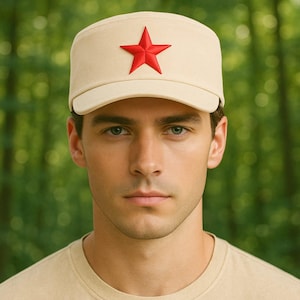 Könnte beinhalten: Beigefarbene Mütze im Militärstil mit rotem Stern. Die Mütze hat einen flachen Schirm und eine strukturierte Krone. Der Hintergrund ist eine verschwommene Ansicht von grünem Laub.