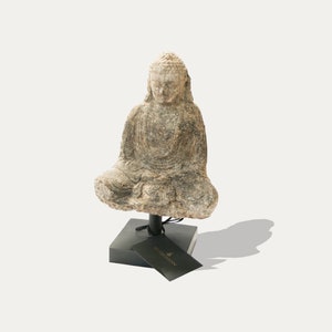 Può includere: Una scultura in pietra di un Buddha seduto, con una finitura consumata, su un piedistallo nero. La scultura è etichettata "remarkable".