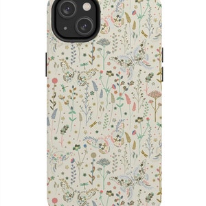 Puede incluir: Una funda de tel&eacute;fono blanca con un patr&oacute;n floral con mariposas, flores y lib&eacute;lulas. La funda tiene un recorte para el objetivo de la c&aacute;mara.