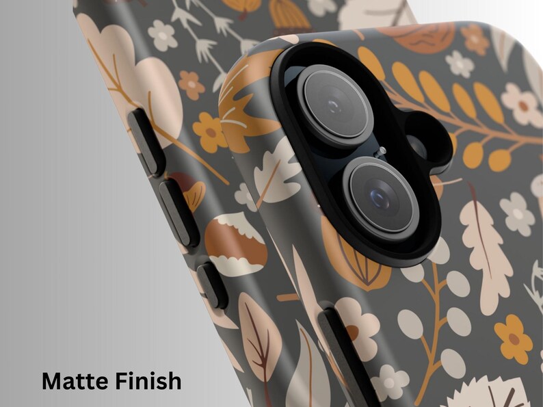 May include: Close-up of a smartphone case with a matte finish. The case features a floral pattern in shades of gray, beige, and orange. The design includes leaves, flowers, and other botanical elements. The text "Matte Finish" is visible at the bottom.
