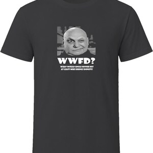 May include: A charcoal gray short-sleeve t-shirt featuring a black and white graphic of Uncle Fester. The text reads "WWFD? WHAT WOULD UNCLE FESTER DO? AT LEAST MIKE BRINGS DONUTS!" in white capital letters centered on the chest of the garment.