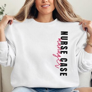 May include: White sweatshirt with the text "NURSE CASE manager" printed vertically on the front. The text "NURSE CASE" is in black and "manager" is in pink.