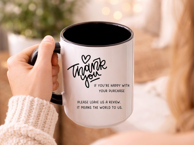 May include: White ceramic mug with a black interior and handle. The mug features the words "Thank you" in a handwritten style, along with the text "If you're happy with your purchase, please leave us a review. It means the world to us."