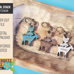 May include: Three laser-cut wooden animal stack keychains. Each keychain features a chicken, a pig, and a goat with the words "CLUCK", "THUMP", and "MAAAAAA" on each animal. The keychains are in different shades of brown and blue.