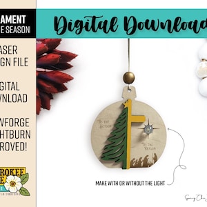 Puede incluir: Un archivo digital de adorno circular de madera con un &aacute;rbol de Navidad verde en capas, una cruz amarilla y una silueta de bel&eacute;n. El texto dice 'Tis the Season' y 'Tis the Reason'. Incluye un lazo para colgar y un detalle de estrella.