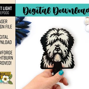 May include: A black and white laser-cut night light design featuring a sheepdog. The image includes the text "Digital Download", "Laser Design File", and "Glowforge + Lightburn Approved!" The design is held by a hand with a turquoise nail polish.
