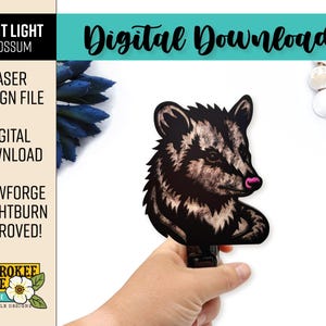May include: A digital download laser design file for a night light featuring an opossum graphic. The file includes text stating NIGHT LIGHT OPOSSUM, LASER DESIGN FILE, DIGITAL DOWNLOAD, GLOWFORGE + LIGHTBURN APPROVED, and CHEROKEE ROSE BY KATIE.
