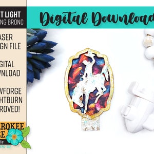 May include: A colorful night light featuring a silhouette of a cowboy riding a horse. The design is set against a background of colorful feathers and a distressed gold frame. The night light is compatible with Glowforge and Lightburn.