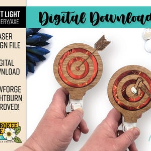 May include: Two wooden night lights shaped like archery targets with a red and gold design. One target has an arrow in the center and the other has an axe. The lights are plugged into an outlet.