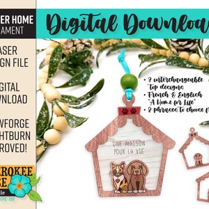 May include: A laser cut wooden ornament shaped like a doghouse with a cat and dog inside. The ornament has the text "Une Maison Pour La Vie" on the front. The ornament is available in two designs, one with the text in French and one with the text in English. The ornament is also available with two different phrases to choose from.