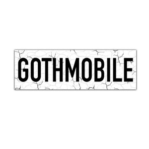 May include: A white rectangular sign with a cracked surface and the word "GOTHMOBILE" printed in black.