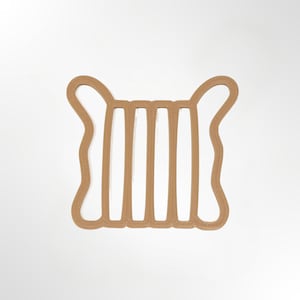 May include: A light brown, flat, square-shaped object with rounded corners and four vertical cutouts. The frame features a continuous, smooth, raised border design that creates a symmetrical, open-grid structure with two distinct ear-like loops at the top.