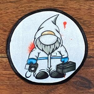 May include: A white gnome wearing a white hooded jumpsuit with a blue face mask, holding a black toolbox and a camera. The gnome is surrounded by red splatters on a white background.