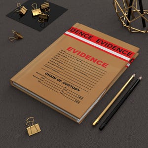 May include: A brown evidence notebook with the word "EVIDENCE" in large red letters. The notebook has a red and white stripe across the top and includes a "Chain of Custody" section. Gold binder clips and pencils are also present.