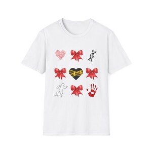May include: White t-shirt featuring a collection of crime scene-themed graphics. Designs include a red heart, DNA strand, red bows, a heart with "CRIME SCENE" tape, a body outline, a red handprint, and more red bows.
