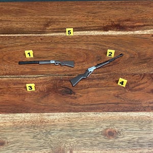 Puede incluir: Dos rifles de juguete sobre una superficie de madera. Los rifles son marrones y negros con detalles plateados. Los rifles están numerados del 1 al 2.