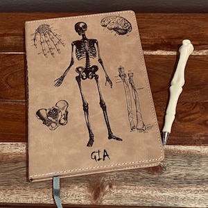 Spersonalizowany jasnobrązowy skórzany notes z liniowanym papierem i długopisem z kością, anatomia, części ciała, antropologia medyczna i sądowa