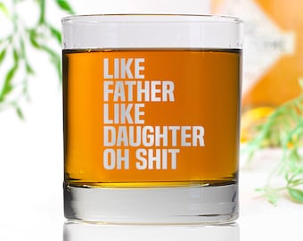 Könnte beinhalten: Ein durchsichtiges Glas mit dem Text "Like Father Like Daughter Oh Shit" auf der Seite. Das Glas ist mit einer hellbraunen Flüssigkeit gefüllt.