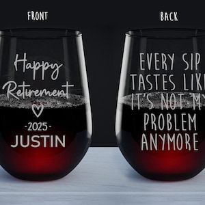 May include: Two stemless wine glasses filled with red wine. The front glass reads "Happy Retirement" with a heart, the year 2025, and the name "Justin". The back glass says "Every sip tastes like it's not my problem anymore."