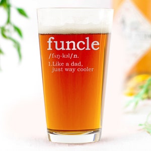 May include: A clear glass beer mug with a brown beer inside. The mug has the word "funcle" written on it with the definition: "/fan-kǝl/n. 1.Like a dad, just way cooler"