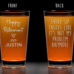 May include: Two shot glasses with an orange gradient fill. The front glass reads "Happy Retirement" with a heart, the year 2025, and the name "JUSTIN". The back glass says "EVERY SIP TASTES LIKE IT'S NOT MY PROBLEM ANYMORE."