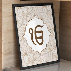May include: A framed art print with a brown floral pattern background. A white and brown emblem is centered on the print. The black frame is angled against a neutral-toned wall and shelf.