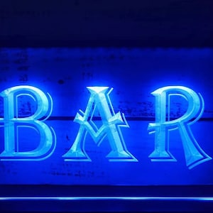 Peut inclure: Enseigne au néon bleue avec le mot "BAR" dans une police décorative.