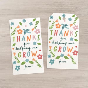 May include: Two white gift tags with colorful floral and bird illustrations. The tags read "THANKS for helping me GROW" in a playful font. One tag is rectangular, the other has a rounded top. Both have a space for "from:"