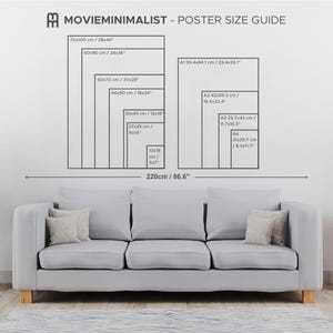 May include: A poster size guide showing dimensions in both centimetres and inches. Sizes include 70x100 cm (28x40 inches) and 60x90 cm (24x36 inches). The guide is displayed above a grey sofa.
