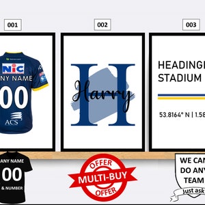 Puede incluir: Tres impresiones enmarcadas con diferentes diseños. La primera impresión presenta una camiseta de rugby azul y blanca con el texto "ANY NAME" y "00". La segunda impresión presenta una letra "H" azul con el texto "Harry" en cursiva. La tercera impresión presenta el texto "HEADINGLEY STADIUM" en azul con el texto "LEEDS" y coordenadas en negro.