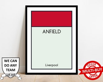 Può includere: Una stampa incorniciata nera con sfondo bianco e accenti rossi e verdi. La stampa presenta le parole "ANFIELD" e "Liverpool".