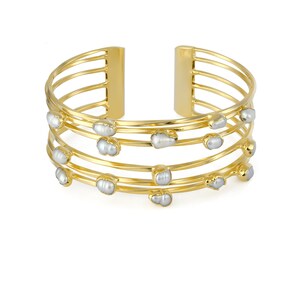 May include: Gold bangle bracelet with five rows of metal and white pearl accents.