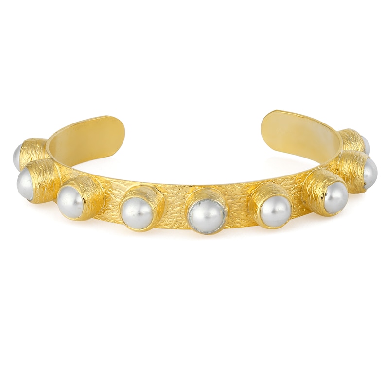 May include: A gold bangle bracelet with a textured surface and white pearl accents.