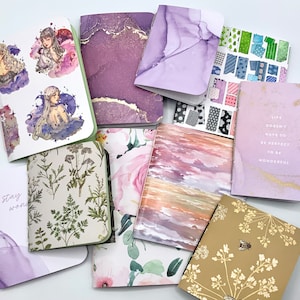 May include: A collection of small, colorful notebooks with various designs. The notebooks feature floral patterns, abstract designs, and inspirational quotes. The notebooks are perfect for journaling, note-taking, or sketching.
