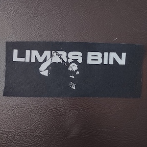 May include: Black and white patch with the text "LIMBS BIN" and a silhouette of a person.