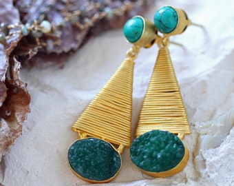 May include: Gold tone earrings with a green and turquoise stone dangle. The earrings have a geometric design with a triangular shape.