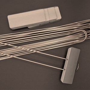 May include: A set of silver plant markers with a silver metal tag and a long, thin metal stake. The stakes are bundled together and the tags are stacked on top of each other.