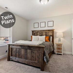 Puede incluir: Un dormitorio con una cama de madera rústica y un cabecero a juego. La cama está hecha con almohadas blancas y naranjas y un edredón gris. Una mesita de noche con una lámpara está al lado de la cama. El texto "Twin Plans" está en un círculo.