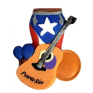 May include: A colorful Puerto Rico-themed figurine featuring a conga drum, a guitar, and a tambourine. The drum is decorated with the Puerto Rican flag. The guitar is orange with the words "Puerto Rico" on it. The tambourine is orange.
