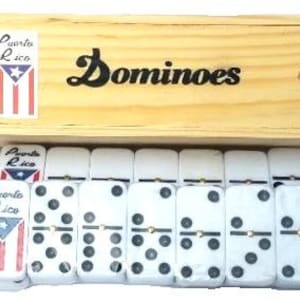 May include: A wooden box with a Puerto Rico flag design and the word "Dominoes" printed on the lid. The box contains a set of white dominoes with black dots.