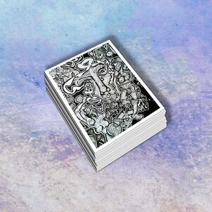 May include: A stack of playing cards with a black and white abstract illustration on the face. The artwork features intricate line drawings of figures and shapes. The cards have white edges and are stacked neatly.