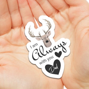 May include: A white sticker with a deer head illustration and the text "I am Always with you" with a black heart and the word "Dad" in a black heart.
