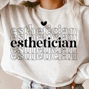May include: A white sweatshirt with the word "esthetician" repeated in black text, with a small heart above the word.