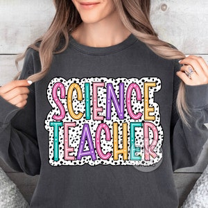 Peut inclure: Un sweat-shirt gris fonc&eacute; avec les mots "SCIENCE TEACHER" en lettres color&eacute;es sur un fond de pois blancs et noirs.